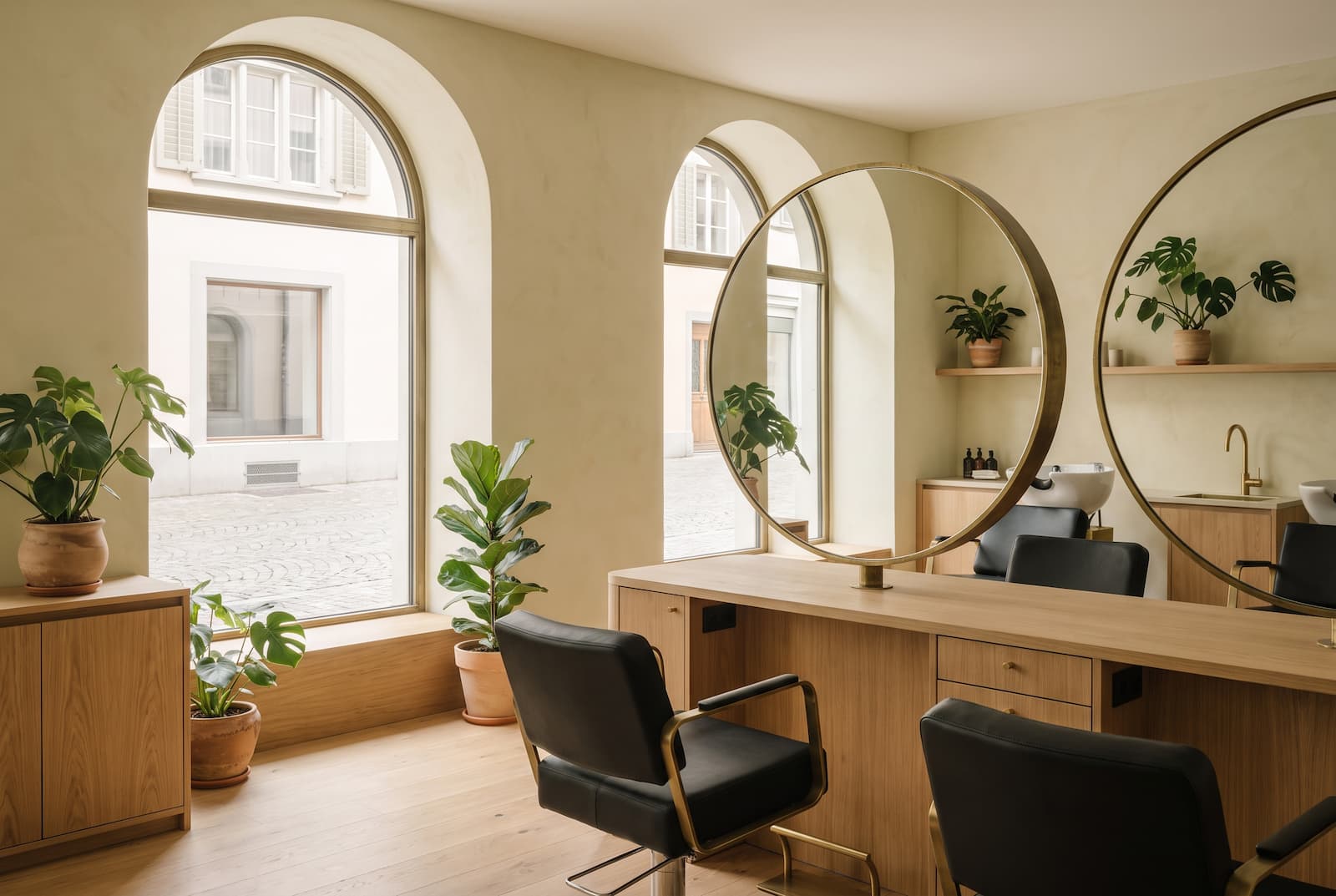 Innenansicht des Salons Lindegg mit Tageslicht, Holz und schwarzen Stühlen
